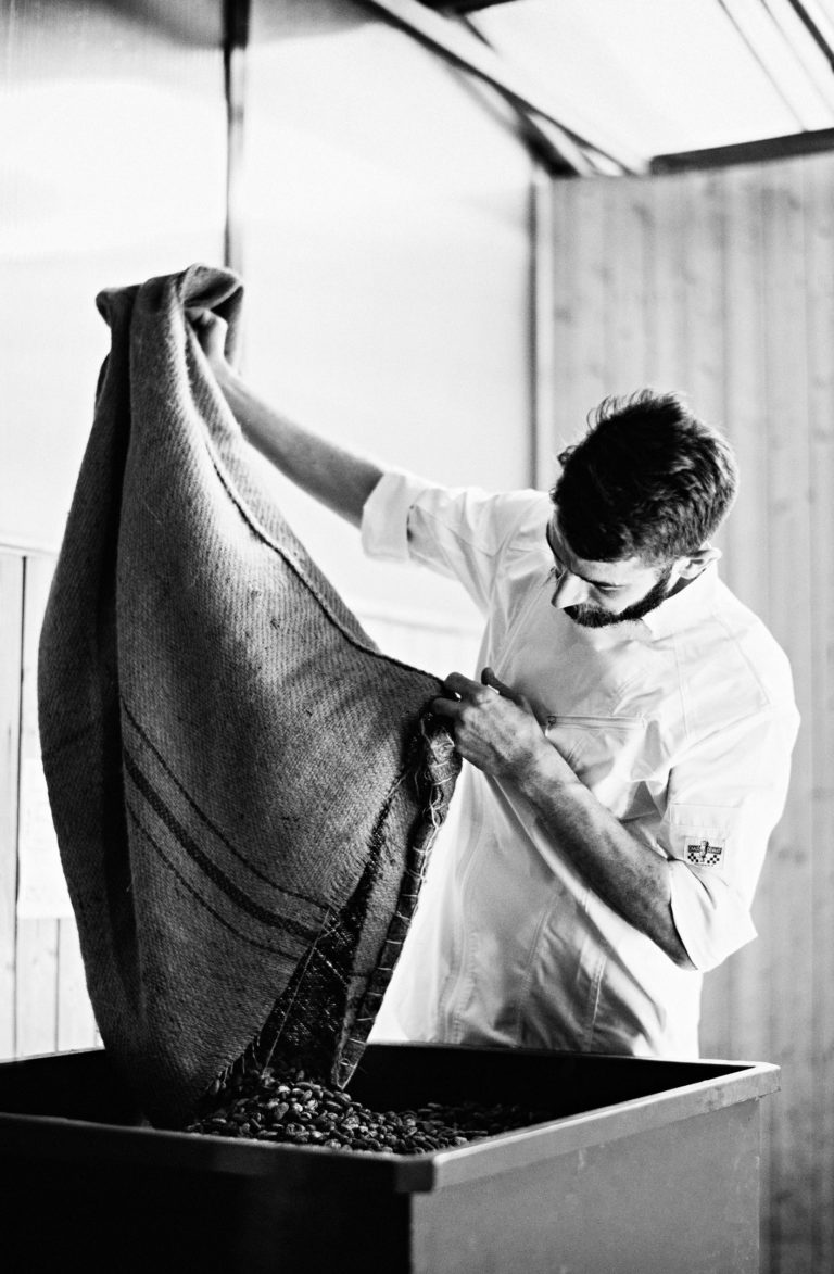 artisan chocolatier qui manipule des fèves de cacao